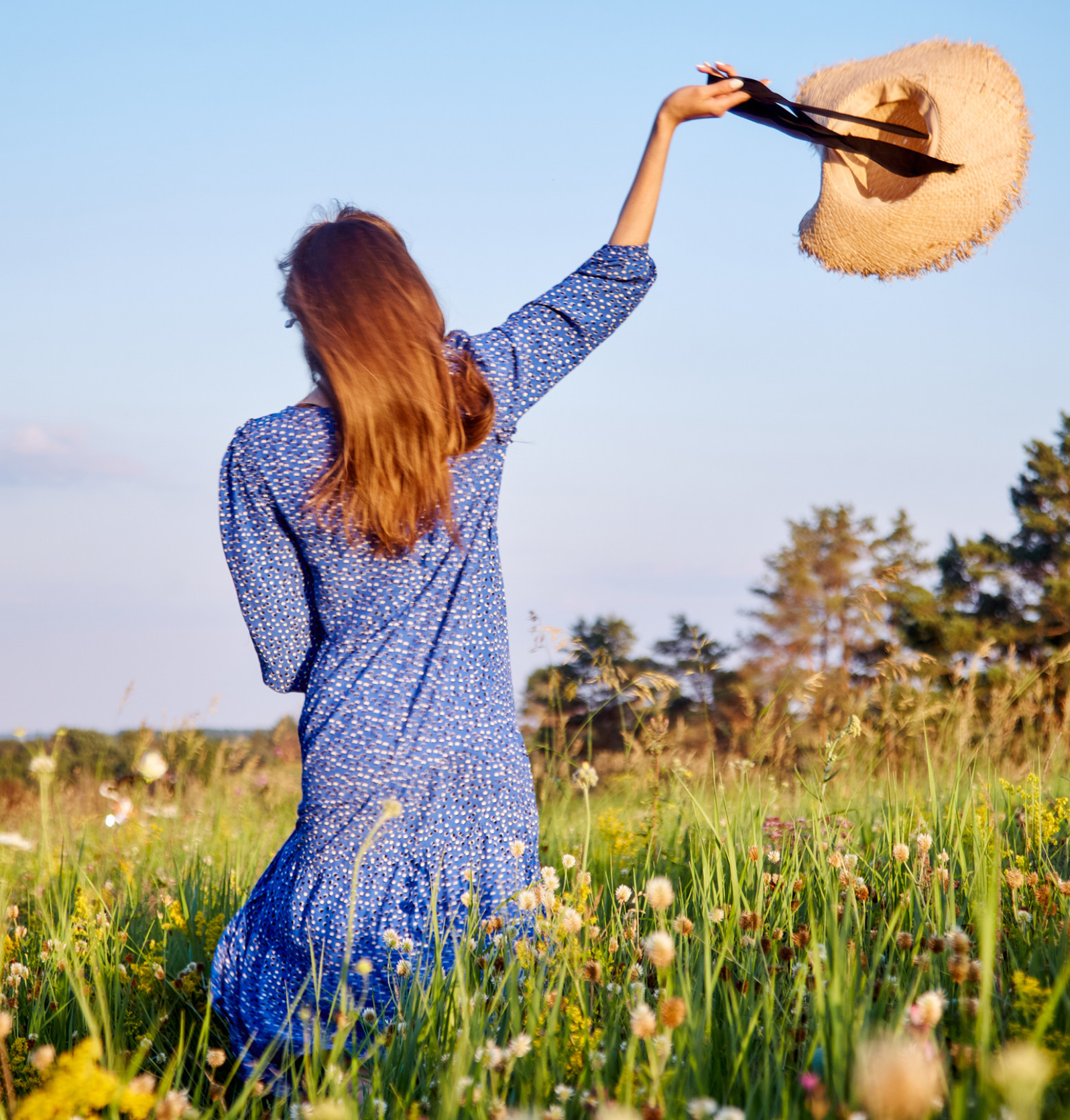 girl in a blue dress walks in the field